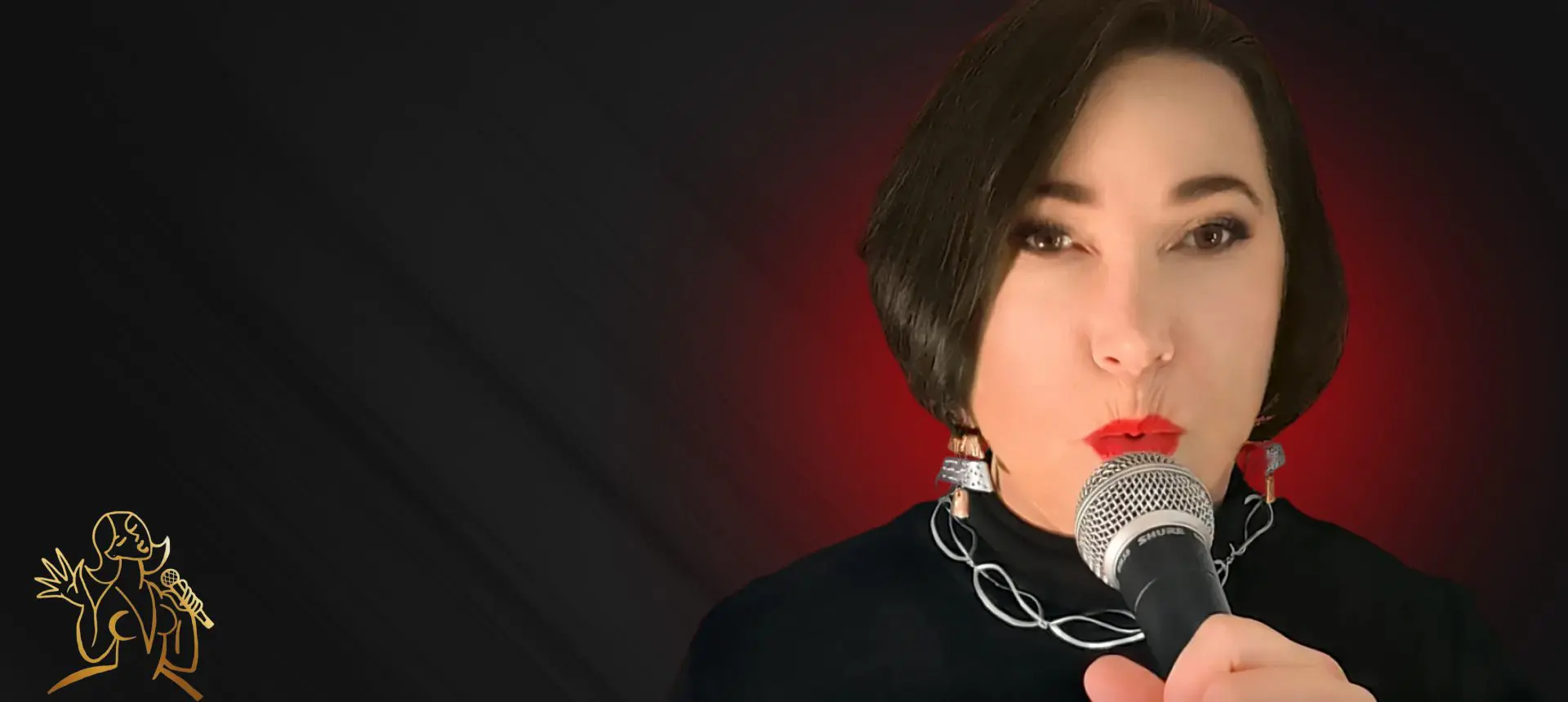 Woman singing into a microphone with a dark background and red lighting.